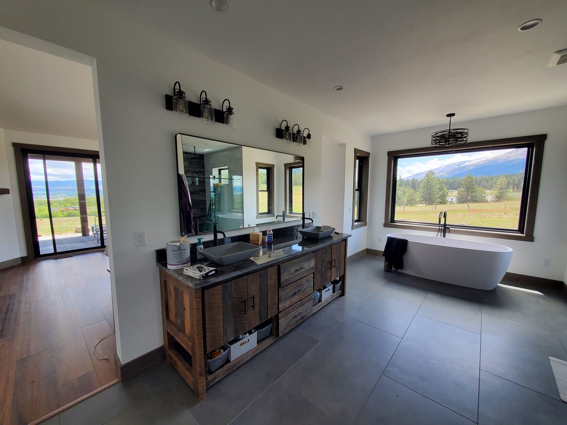 A bathroom with two sinks , a tub and a large mirror.