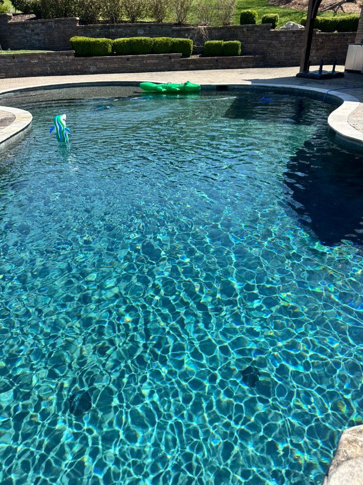 A large swimming pool with a green float in it.