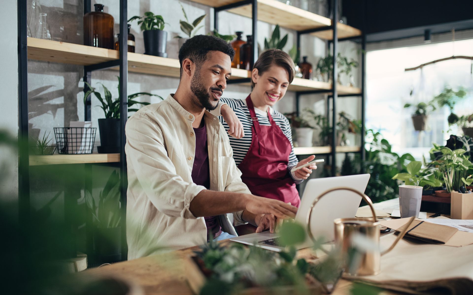 a man and a woman are sitting at a table looking at a laptop on the afoofa software.