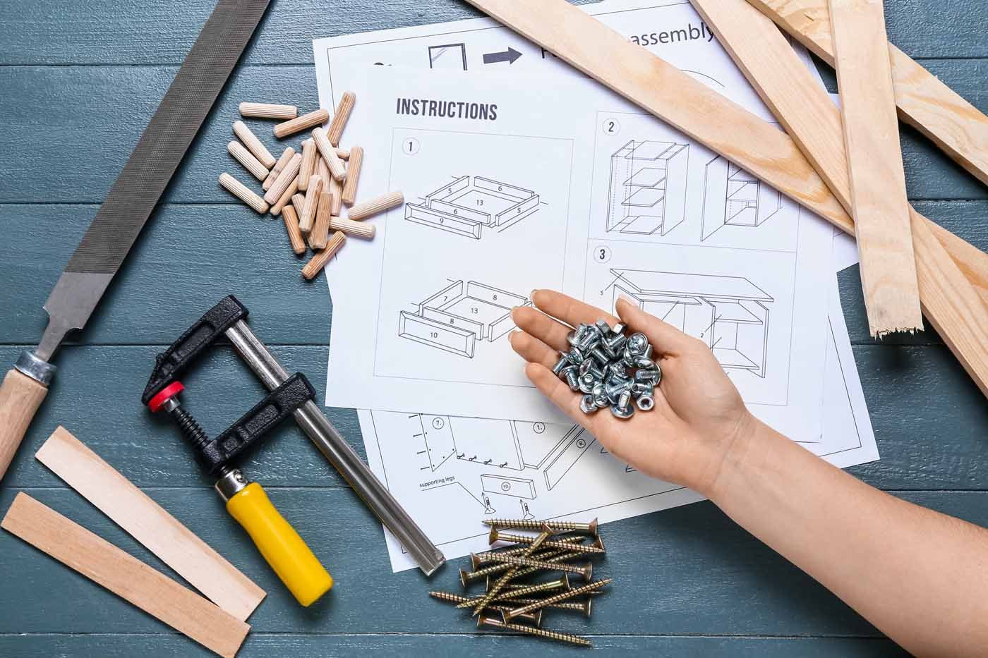 A person is holding a pile of screws in their hand.