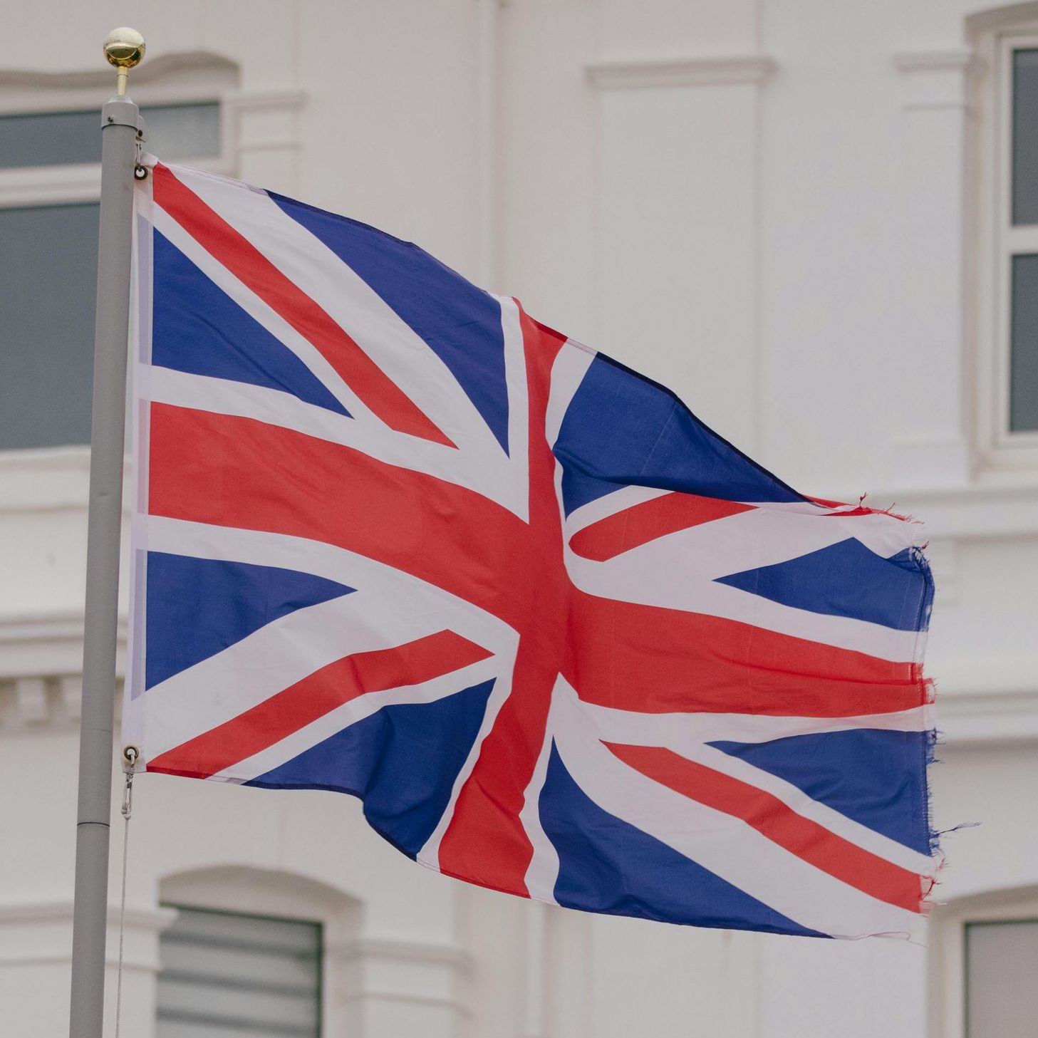 Et britisk flag vajer foran en hvid bygning