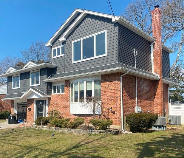 A large brick house with a lot of windows and a chimney.
