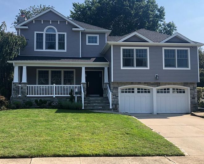 A large gray house with a white garage door