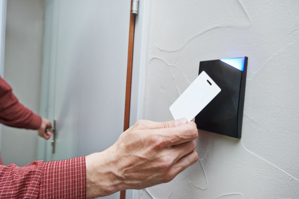 Person Uses Key Card to Unlock a Door With a Black Access Reader — Yamba Locksmiths in Yamba, NSW