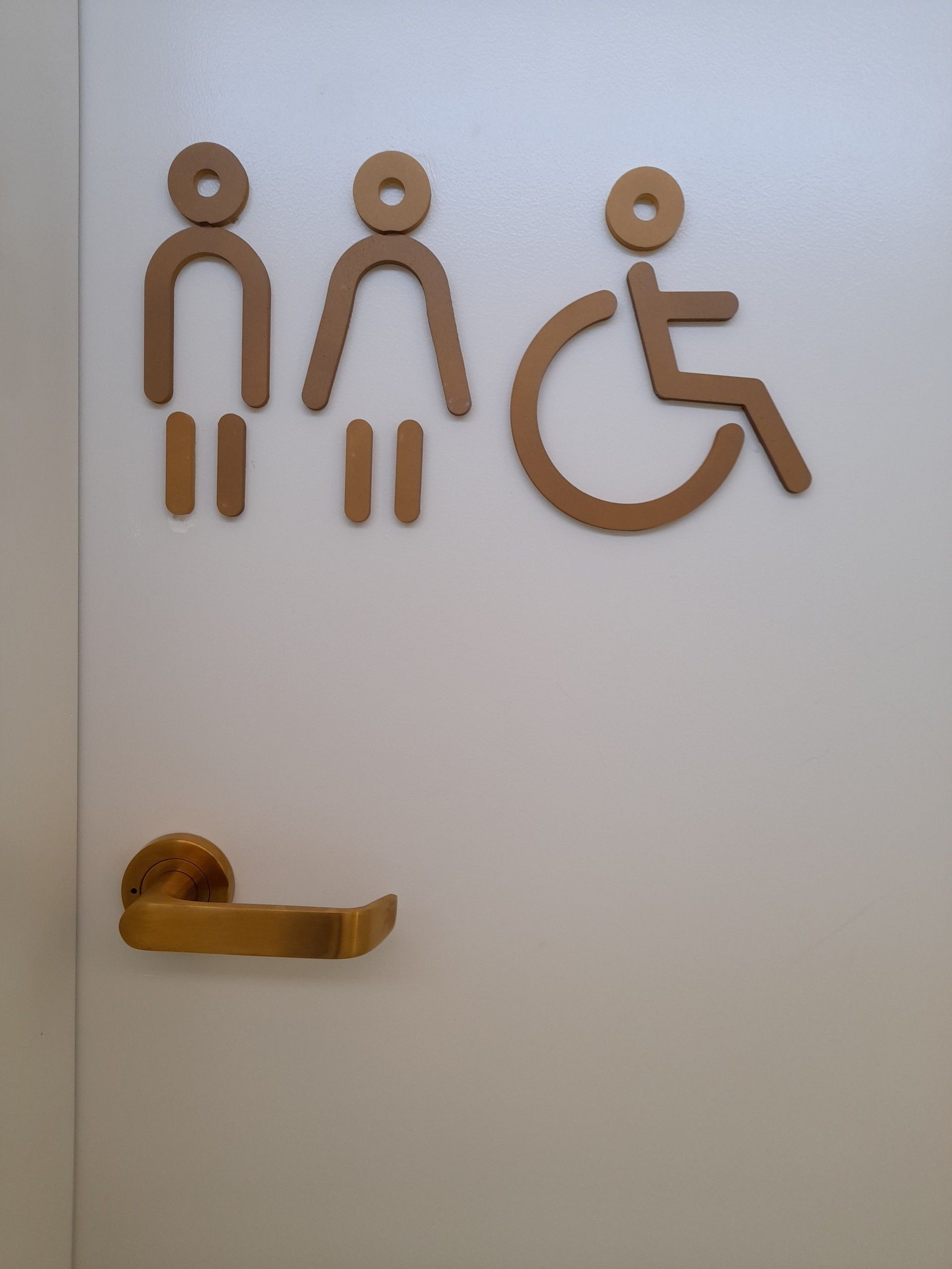 Bathroom door with gold handle and brown gender and accessibility symbols— Yamba Locksmiths in Yamba, NSW