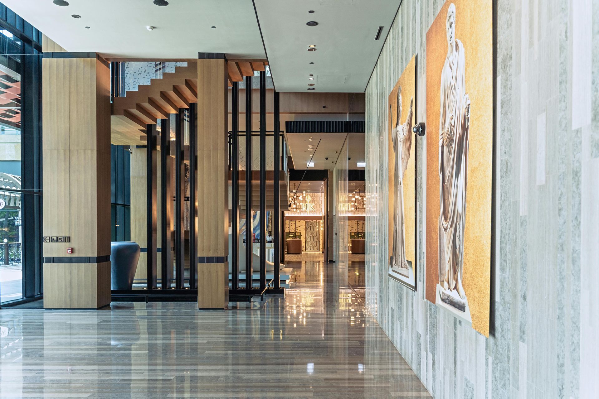 A hotel hallway with a stylish staircase and paintings on the wall, after refurbishment.