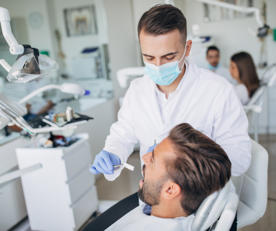Dentist wearing a mask examines a patient in a bright dental clinic