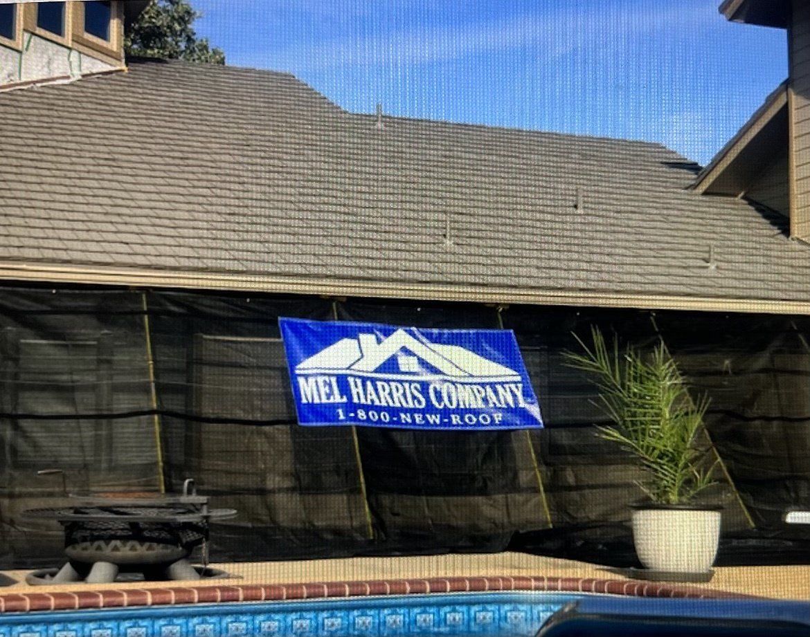 A sign for mel harris company is hanging on the side of a building next to a pool.