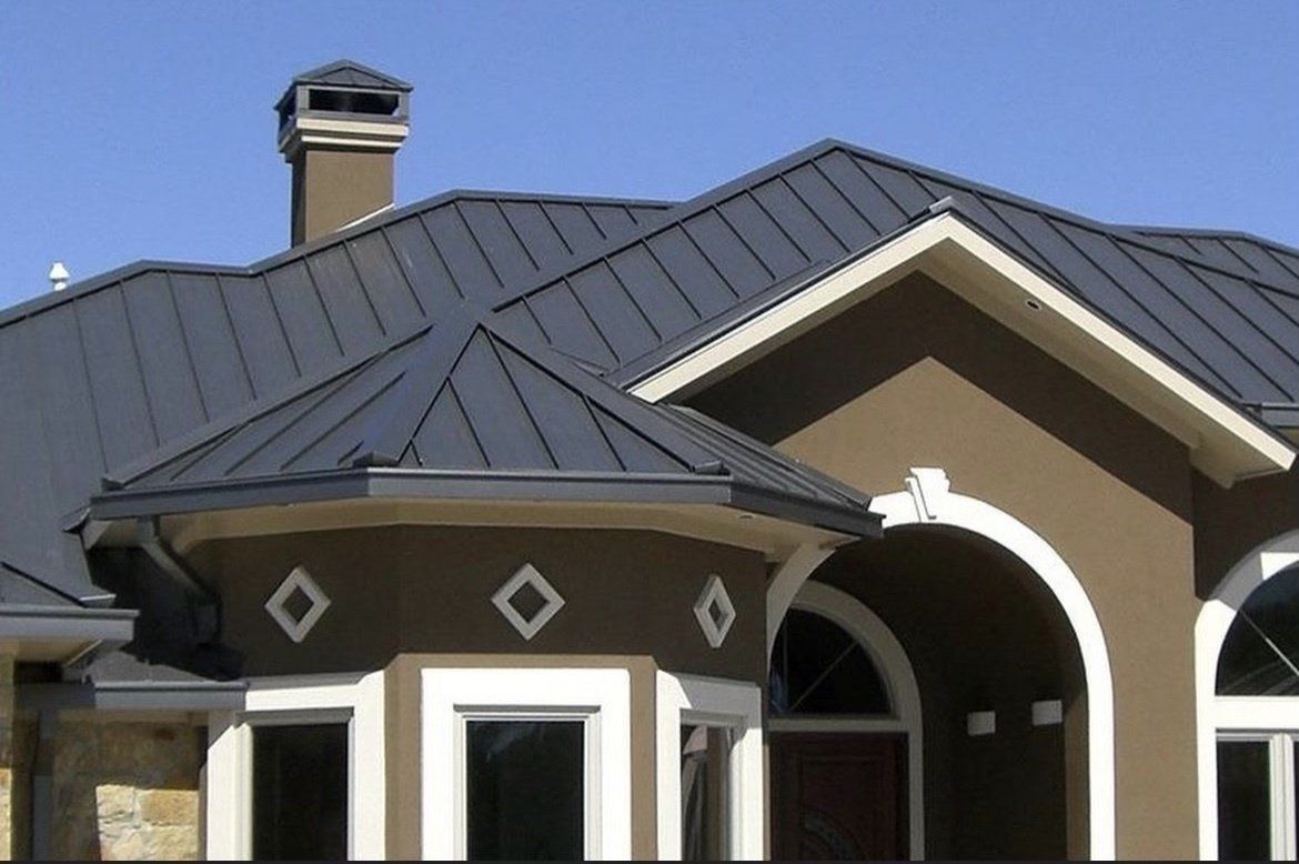 A brown house with a black roof and a chimney