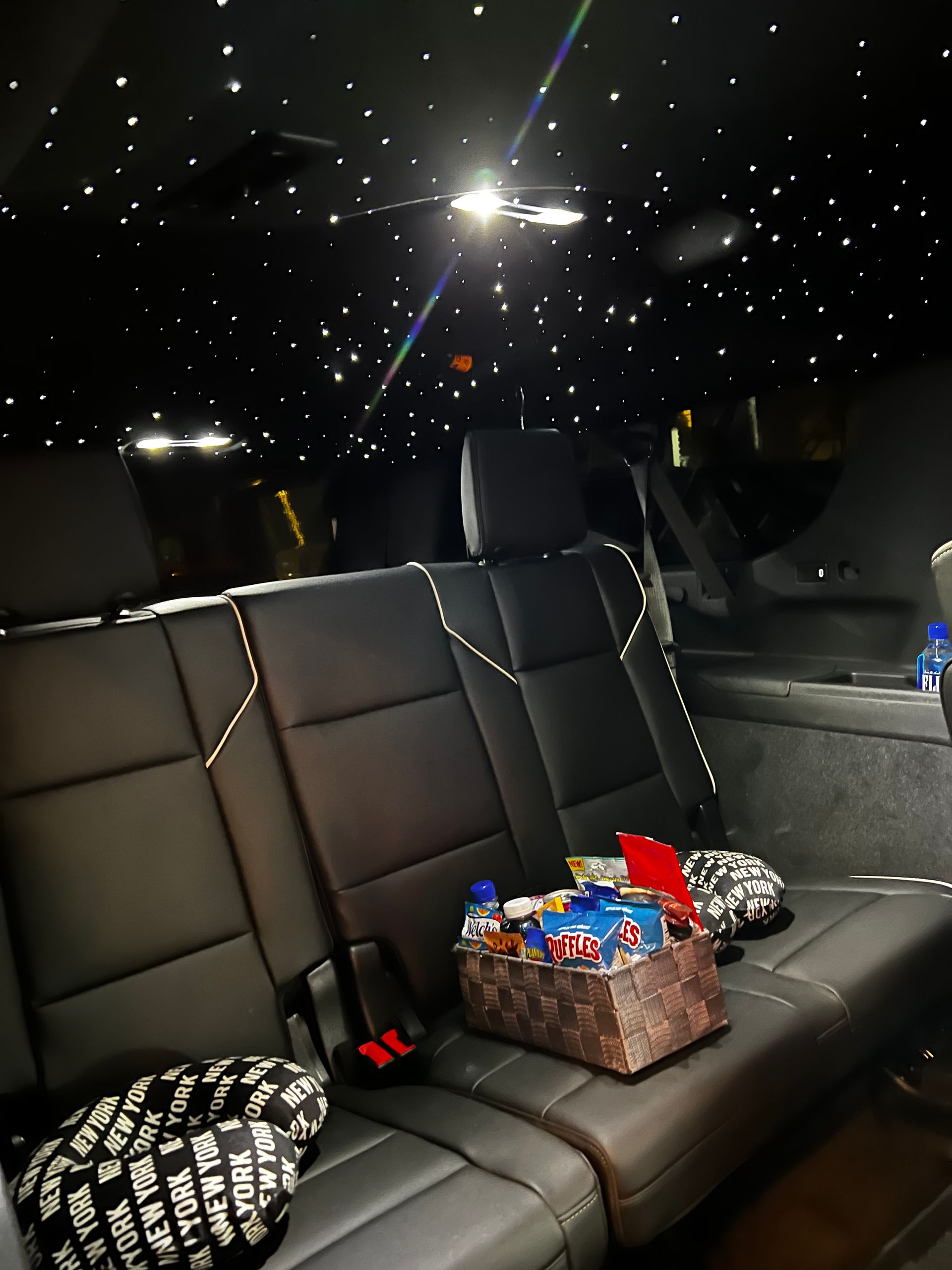 The back seat of a car with a starry ceiling