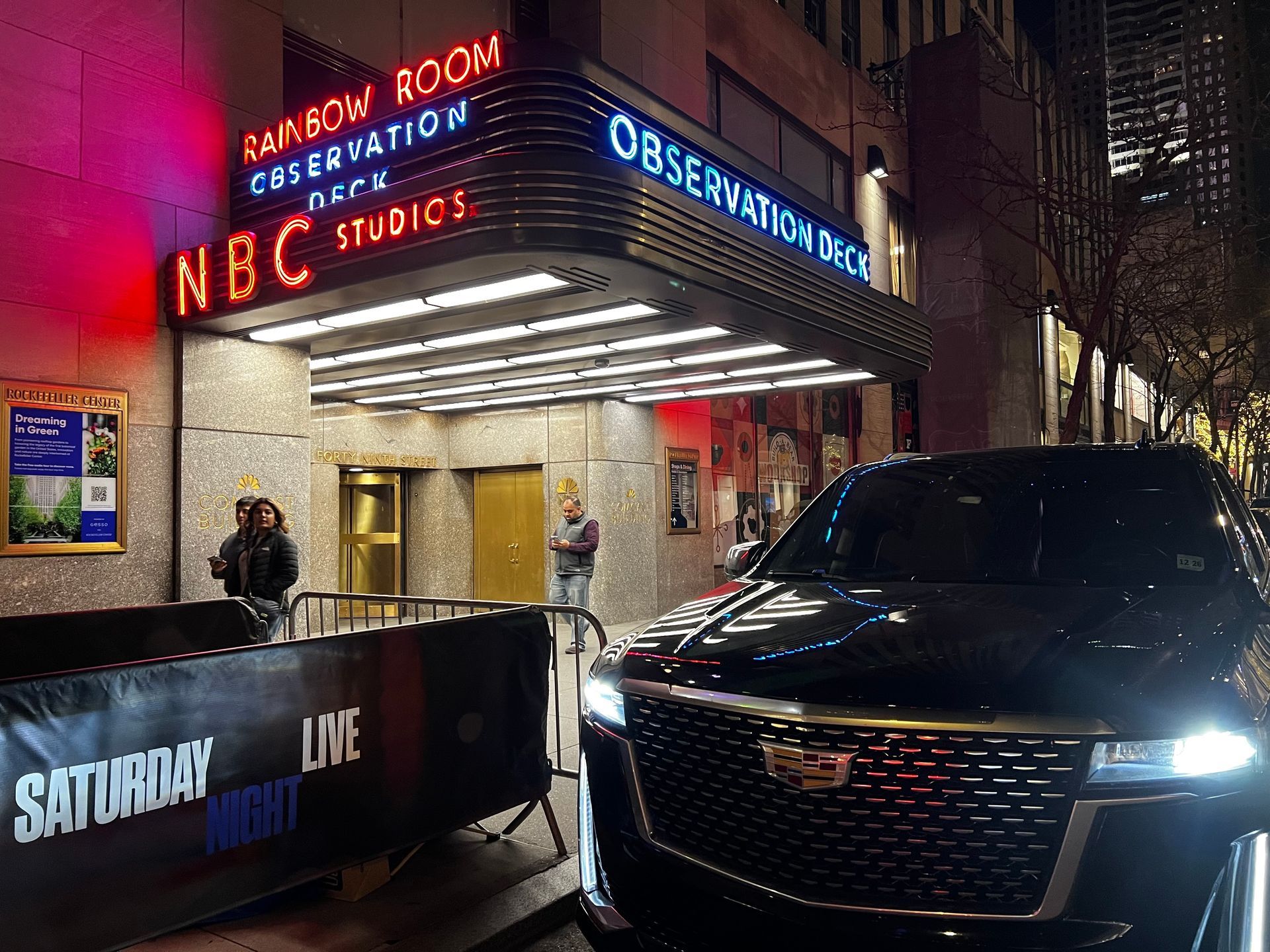 A car is parked in front of a building that says nbc studios.