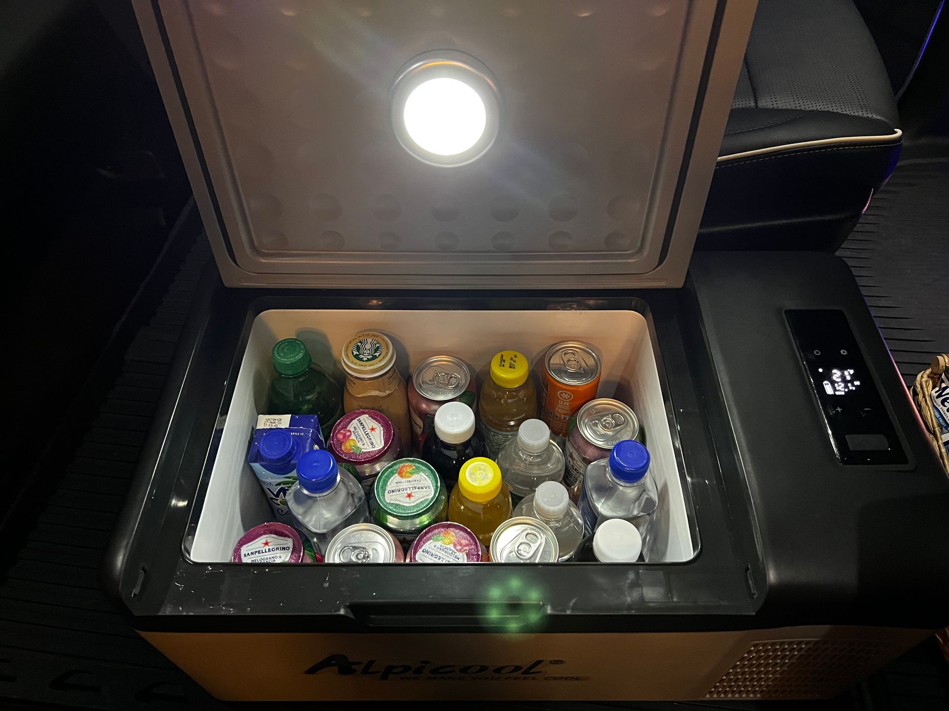 A refrigerator filled with bottles , cans , and ice cream.