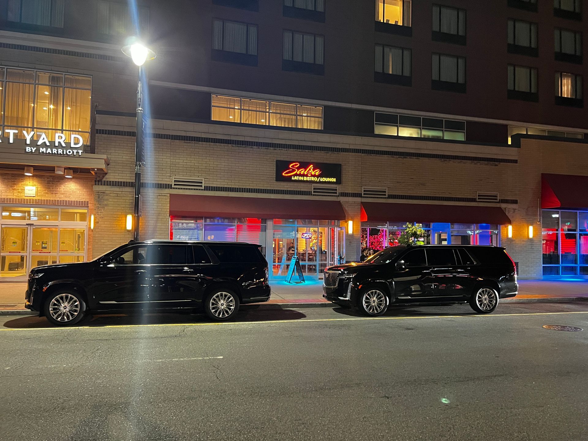 Two cars are parked in front of a building that says courtyard