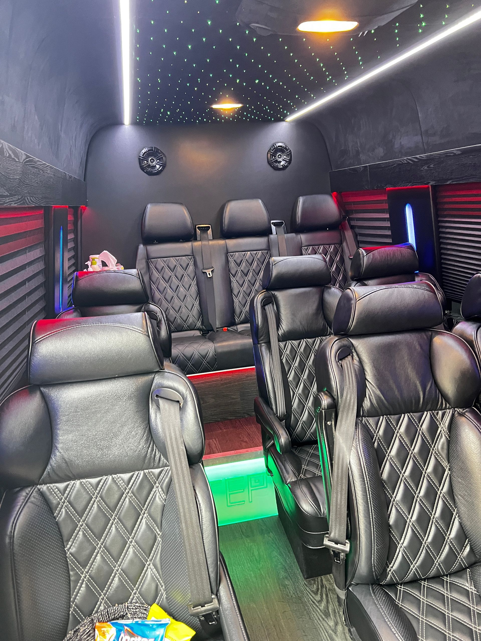 The inside of a van with a lot of seats and lights.