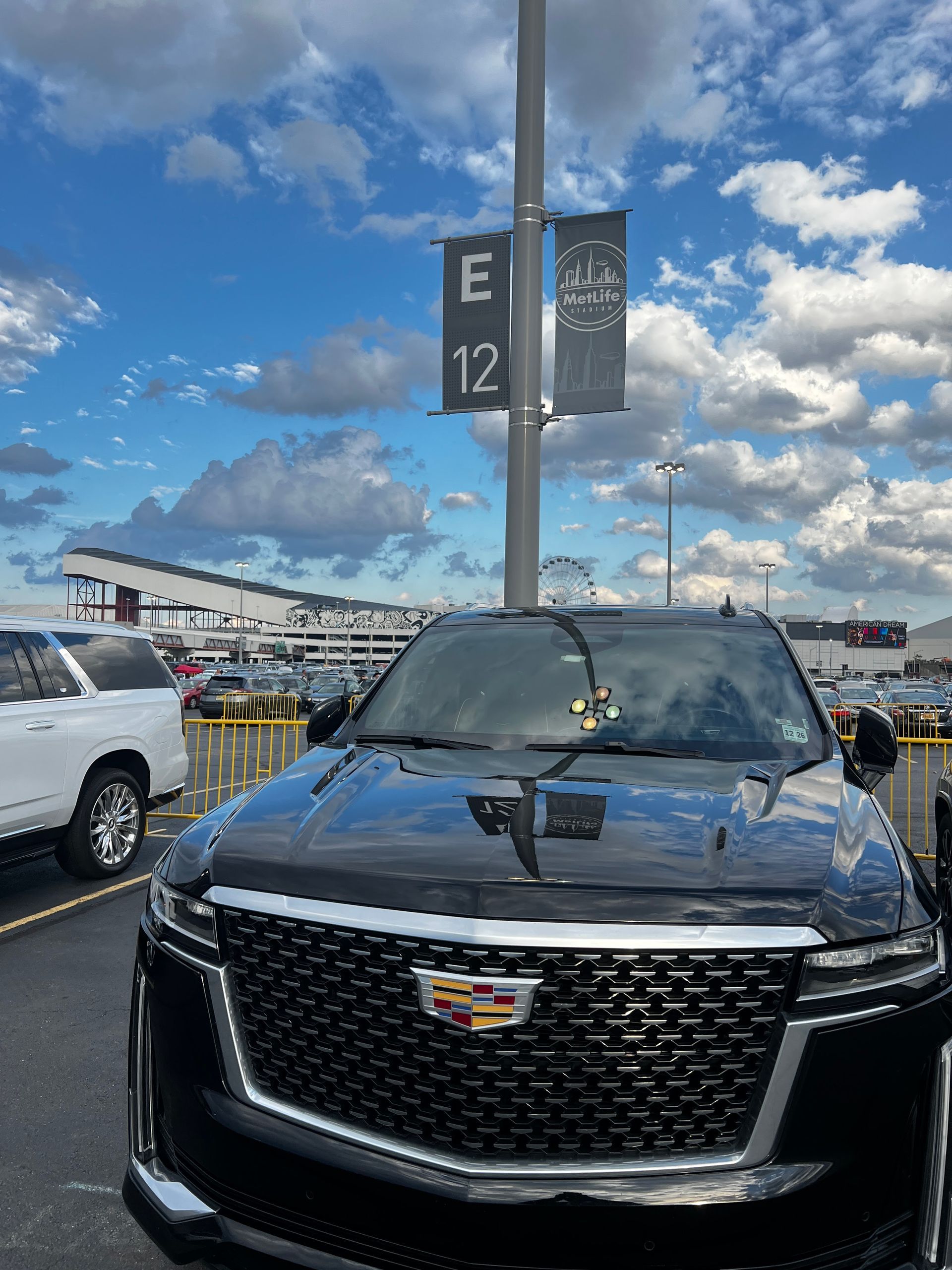 A black cadillac is parked in a parking lot.
