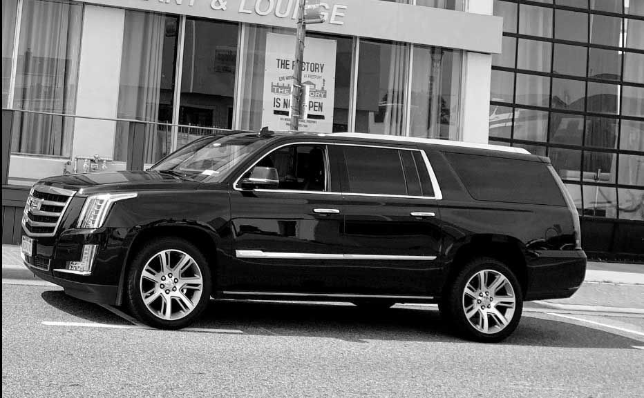 A black suv is parked in front of a building.