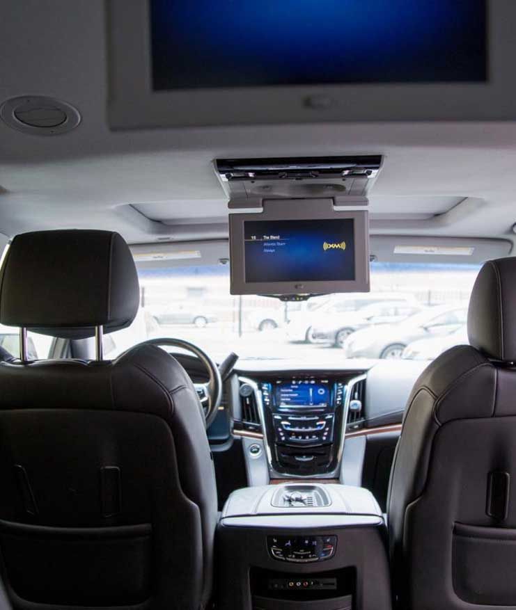 The back seat of a car with a tv mounted to the ceiling