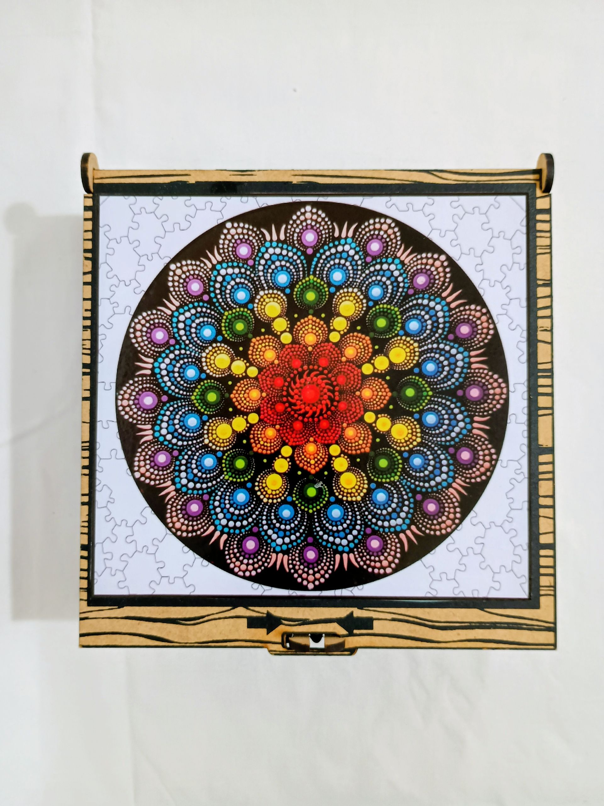 Caja de madera con diseño de mandala colorido en la tapa.