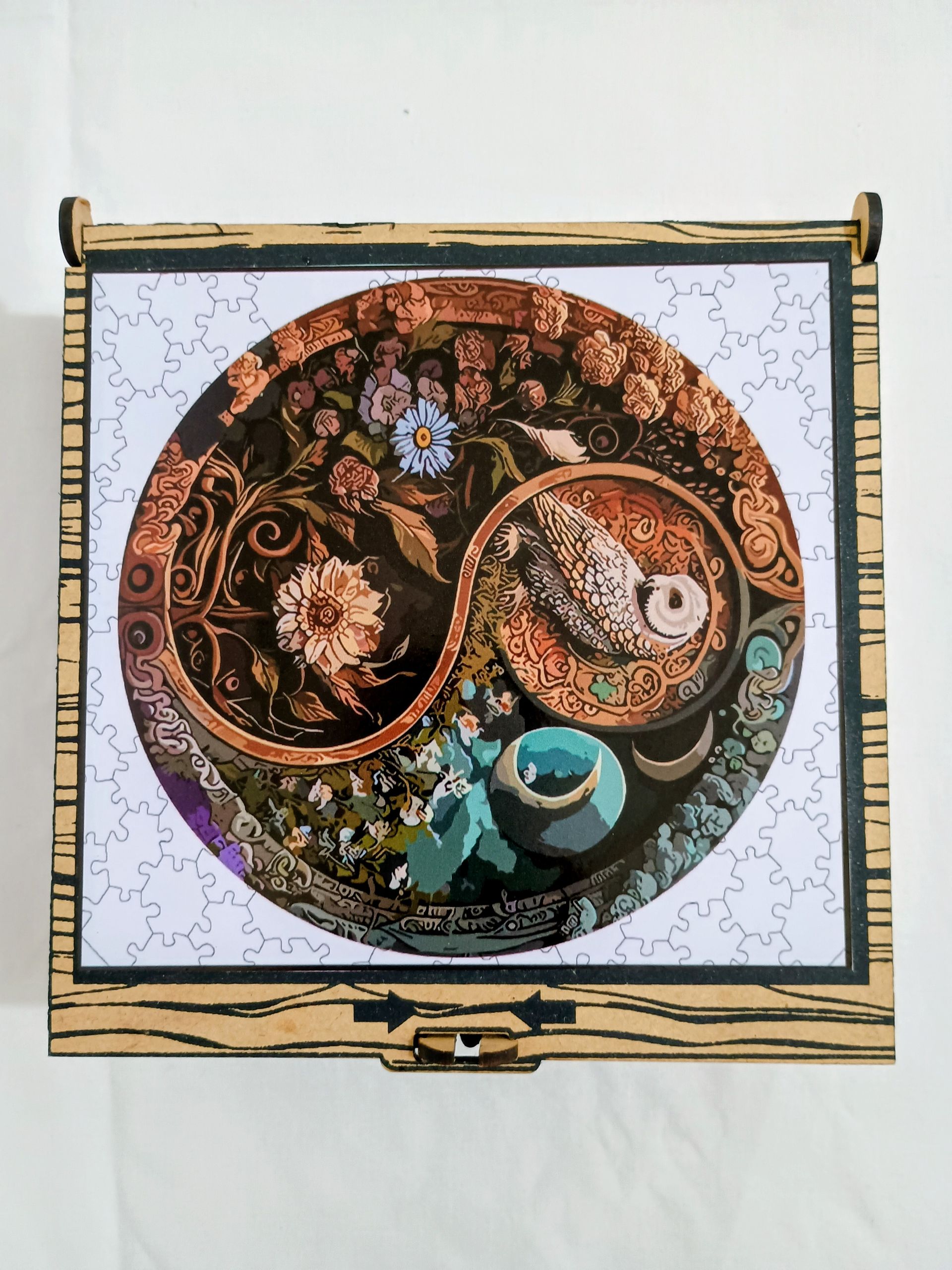 Caja de madera con diseño Yin Yang de flores y una taza de té en el centro.