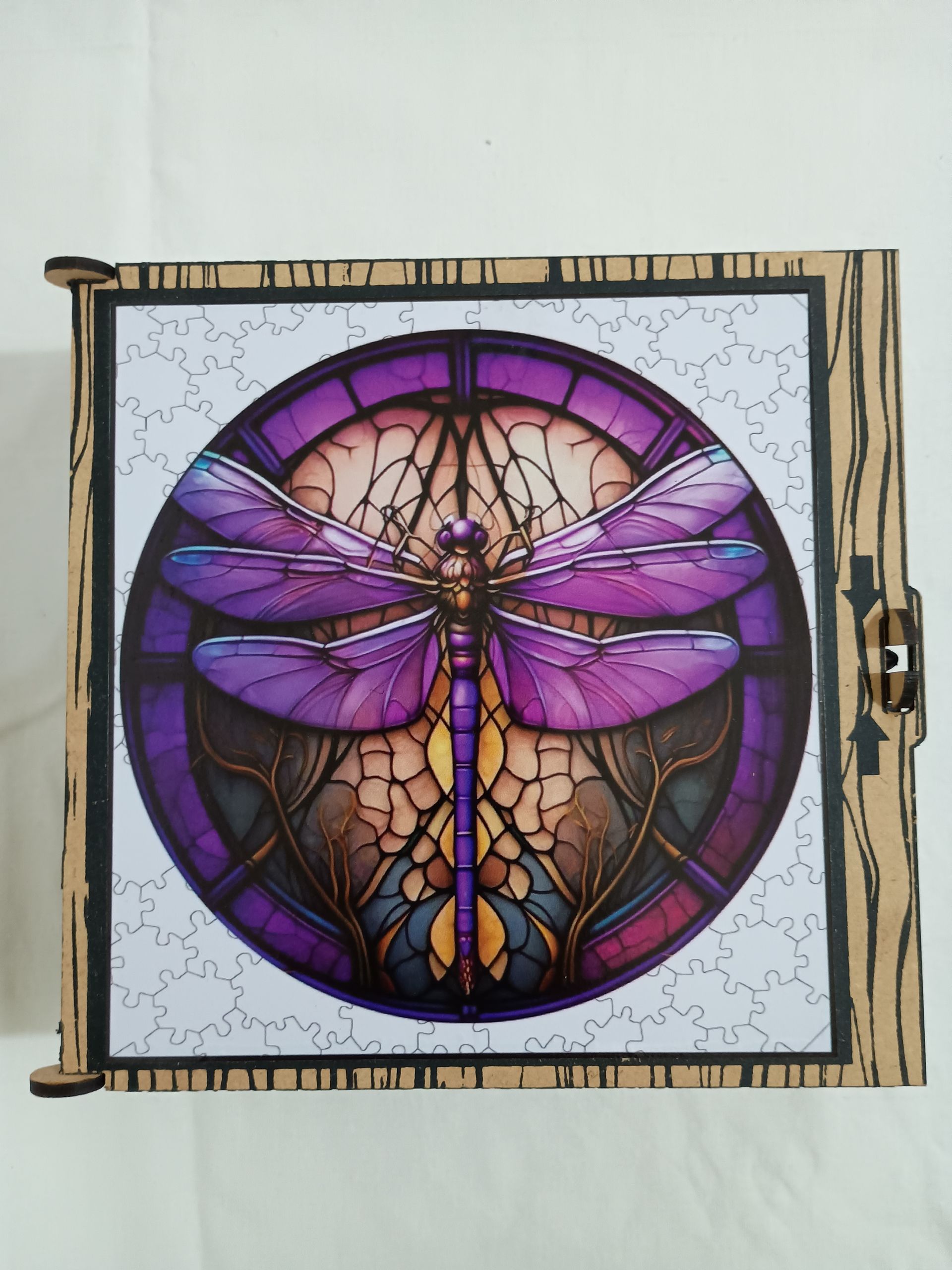 Caja de madera con diseño de vitral en forma de libélula de color morado.