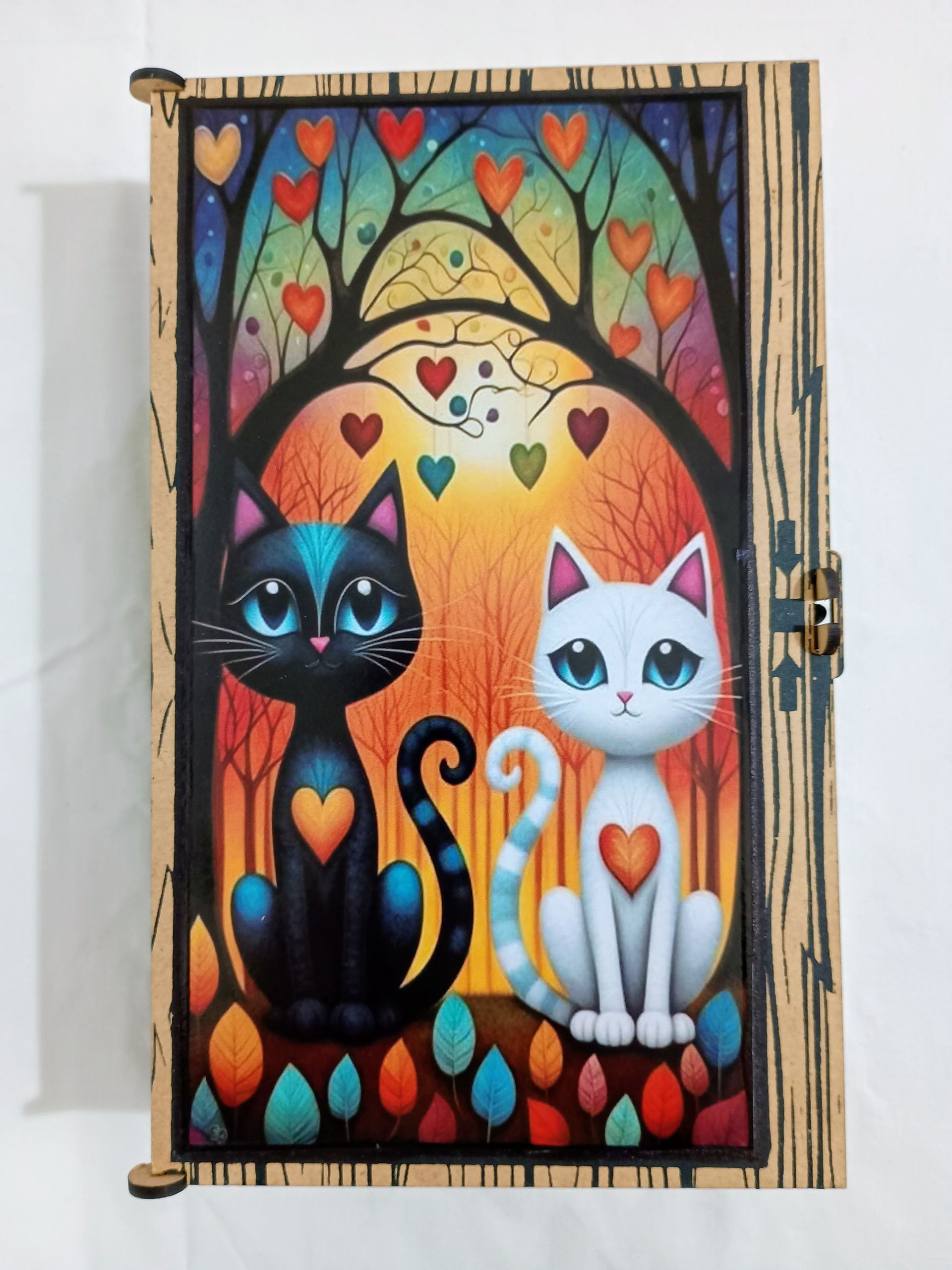 Caja de madera con una escena pintada de colores: dos gatos, uno negro y otro blanco, con corazones en el pecho