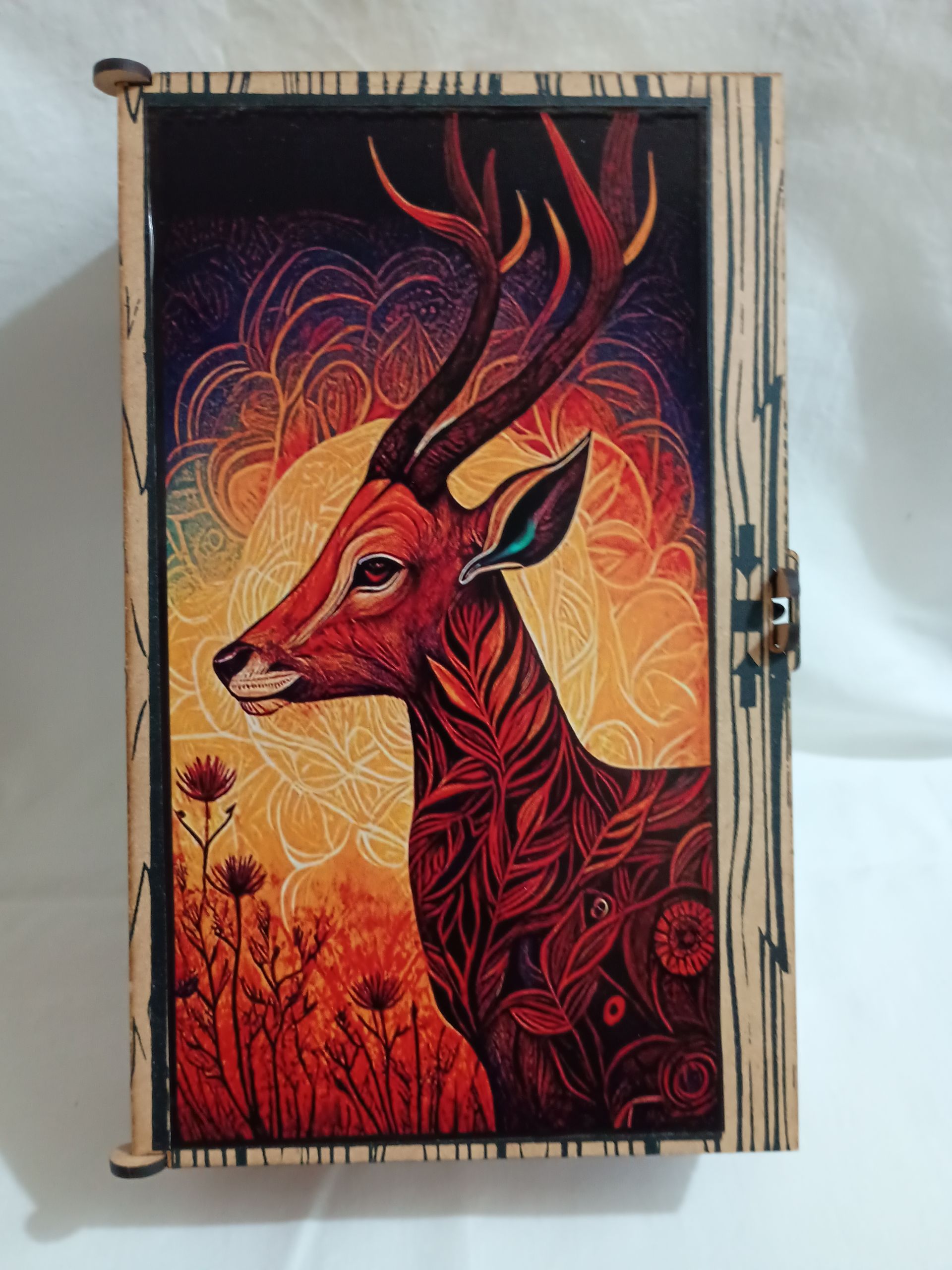 Caja de madera con ilustración de ciervo en colores cálidos.