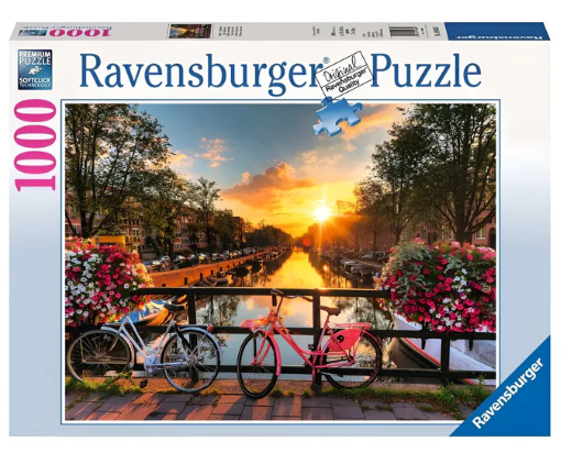 Puesta de sol sobre el canal de Ámsterdam con bicicletas en un puente y flores de colores.