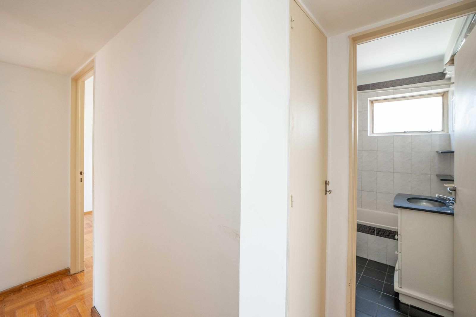 Edificio de apartamentos alto de ladrillo, visto desde abajo, rodeado de árboles verdes.