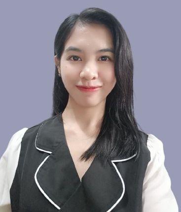 Man with a short, spiky haircut and stubble, smiling. Wearing a blazer and light blue shirt, with a blue background.