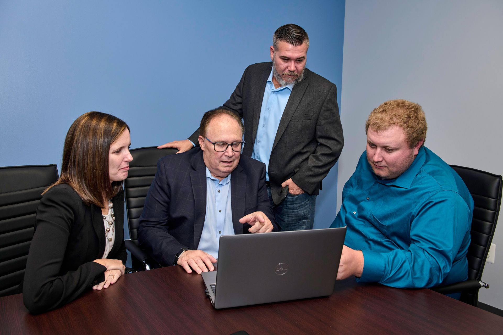 A woman is standing in front of a whiteboard and smiling.