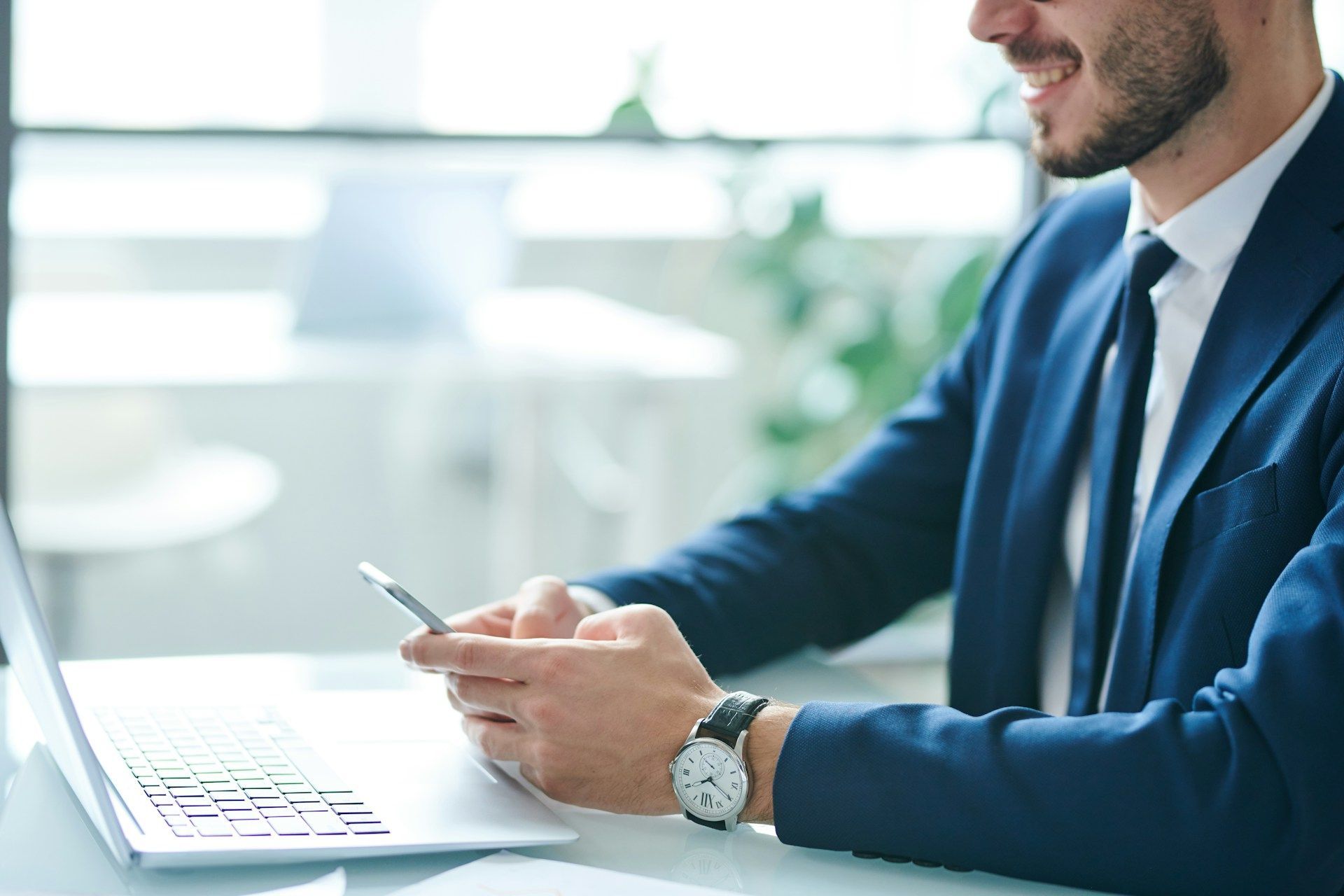A group of people are sitting around a table with laptops.