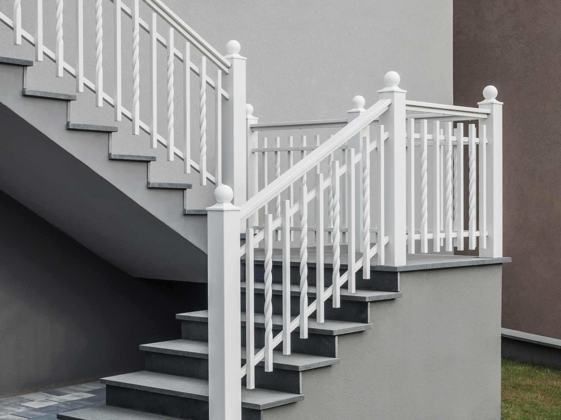 Gray outdoor staircase with white railing.