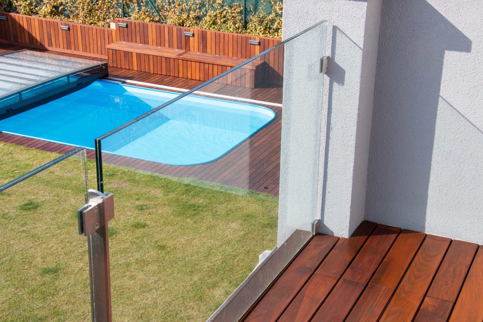 Glass railing along interior staircase with metal supports.