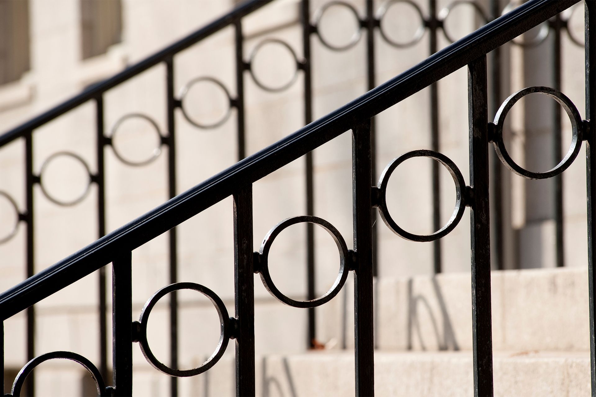Black metal stair railing with circular accents.