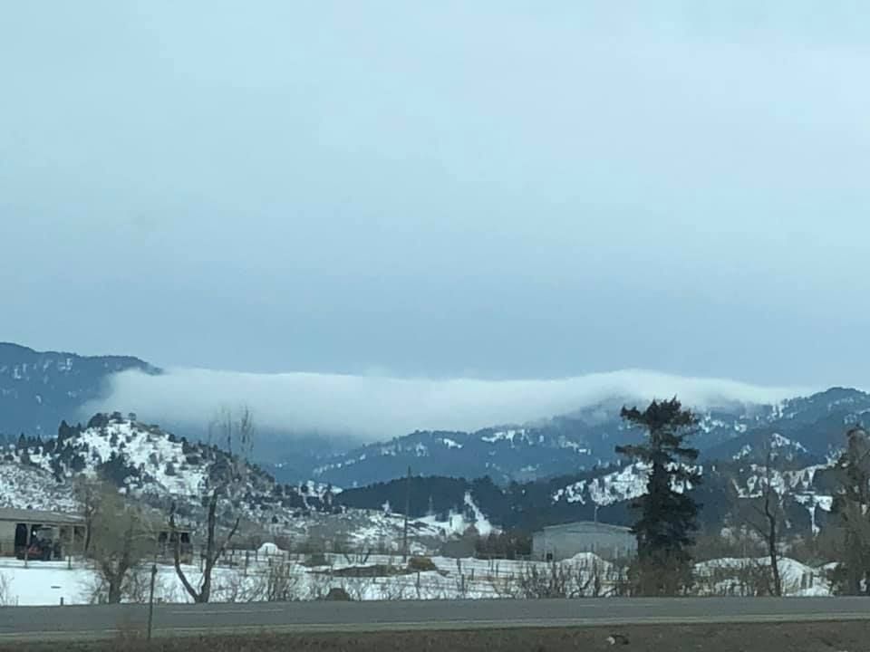 A view of a snowy mountain range from a highway.