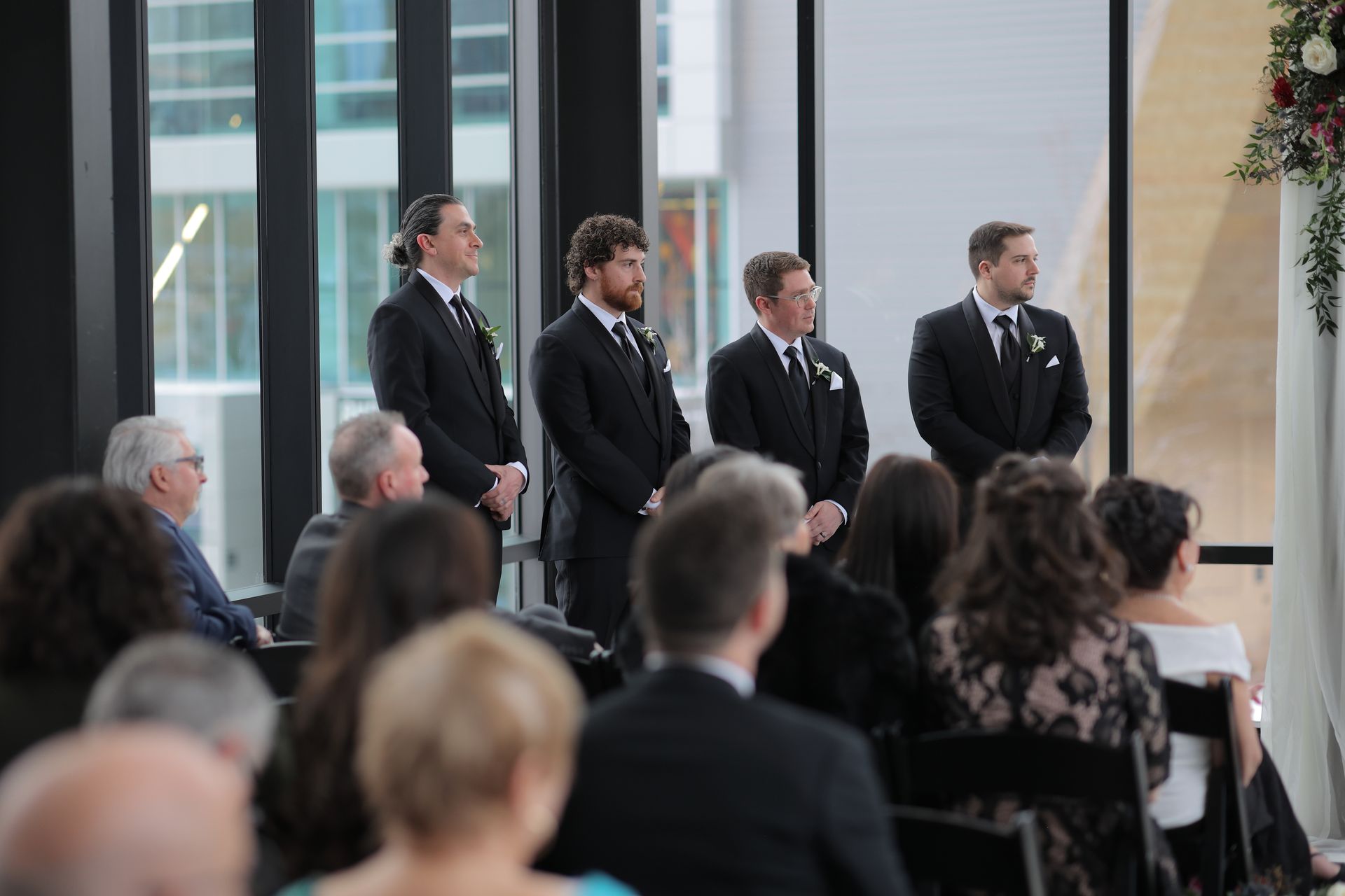 Groomsmen waiting at a modern wedding ceremony, looking toward the aisle. Guests seated in the foreground.
With Love, Wedding management, Milwaukee Wedding Coordinator
