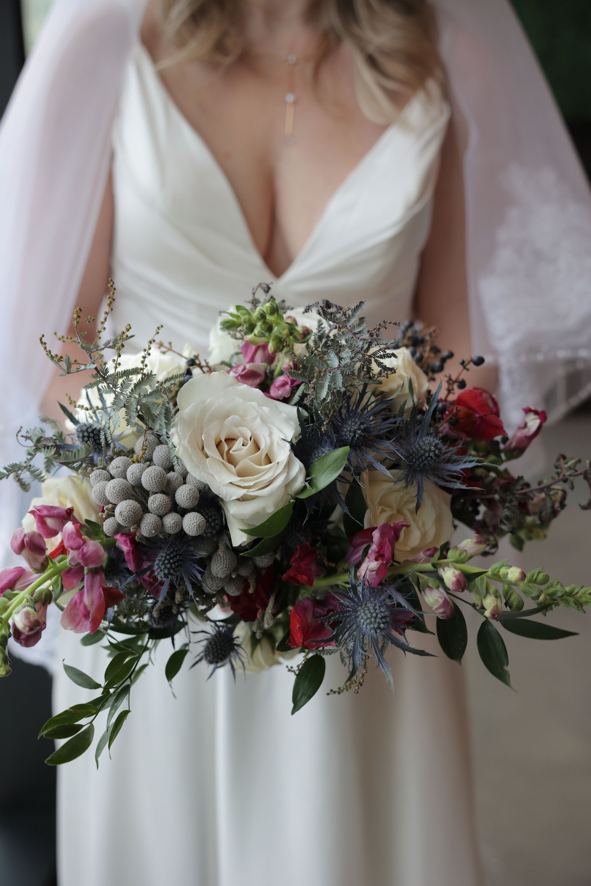 Bride in a white dress holding a bouquet of flowers with a veil.
With Love, Wedding management, Milwaukee Wedding Coordinator