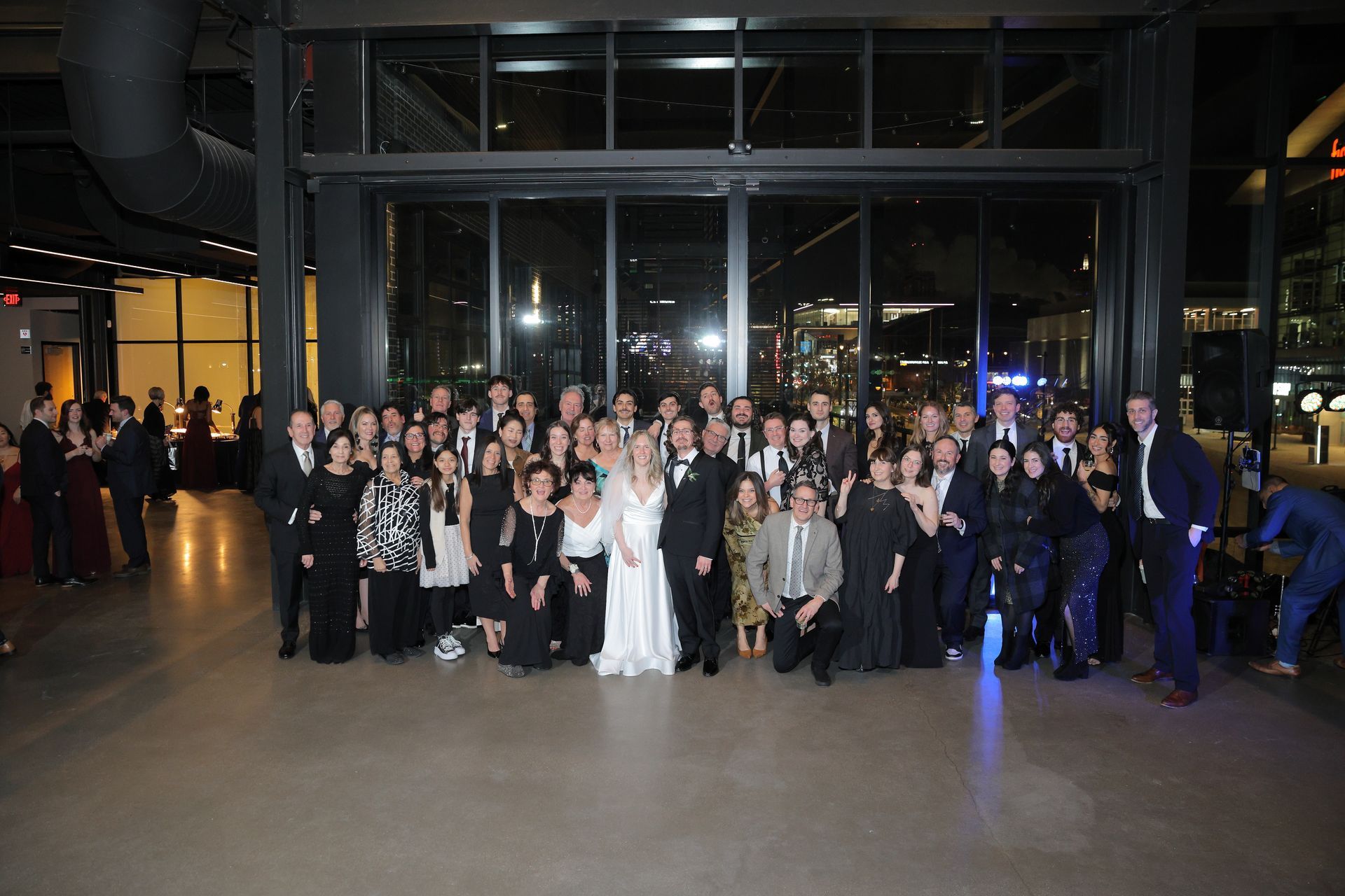 Large group of people in formal attire pose in front of a window at a nighttime event.
With Love, Wedding management, Milwaukee Wedding Coordinator