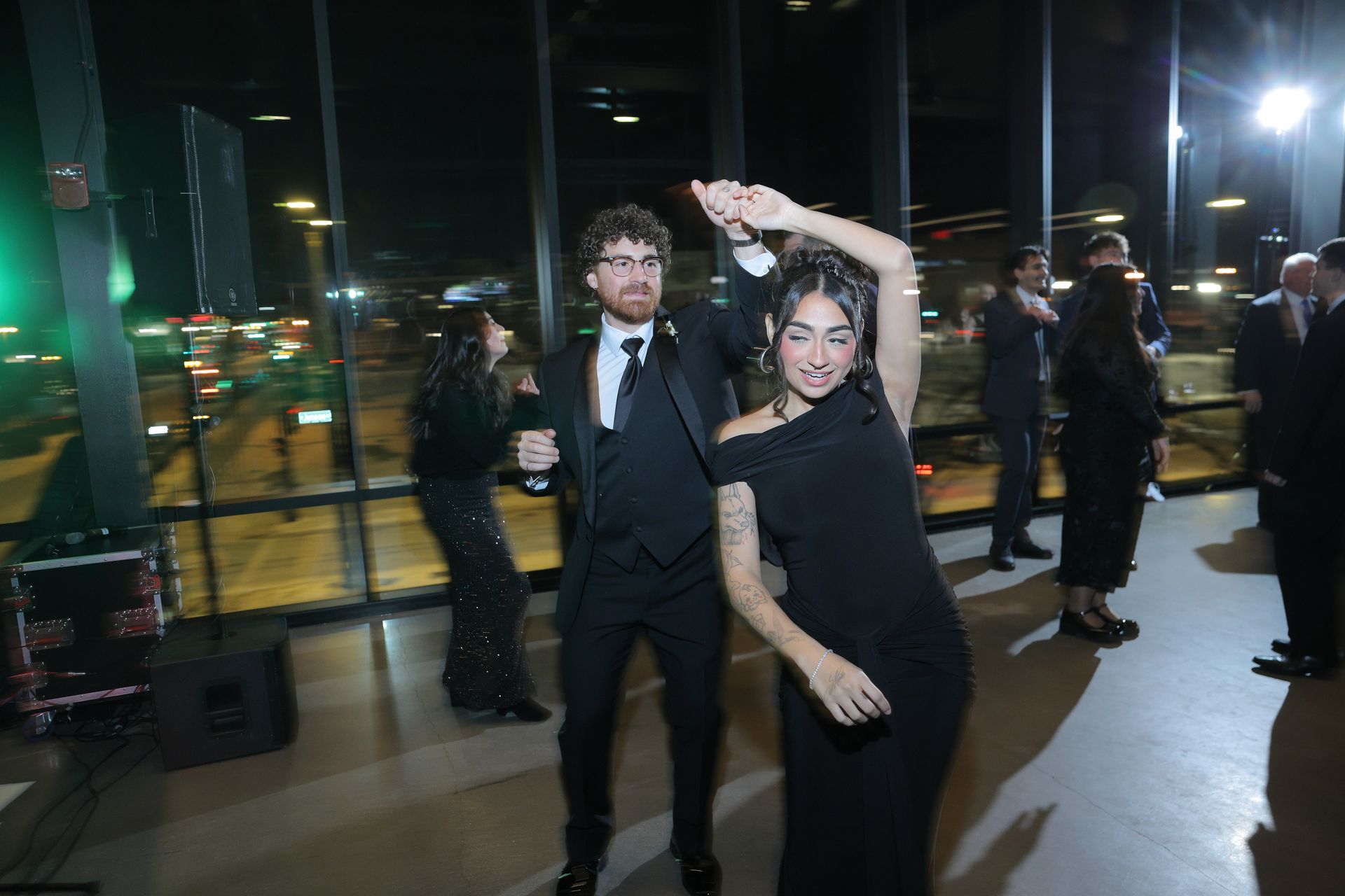 Couple dancing at a party by a window, night view of city lights. They wear formal black attire.
With Love, Wedding management, Milwaukee Wedding Coordinator