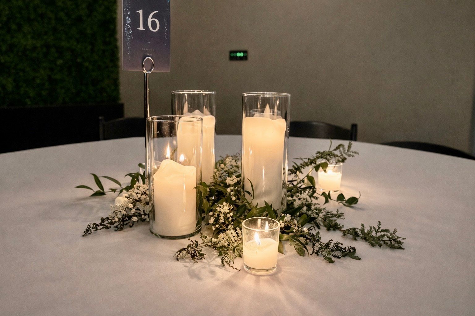Centerpiece with white candles, greenery, and table number 16 on a round, white-covered table.
With Love, Wedding management, Milwaukee Wedding Coordinator