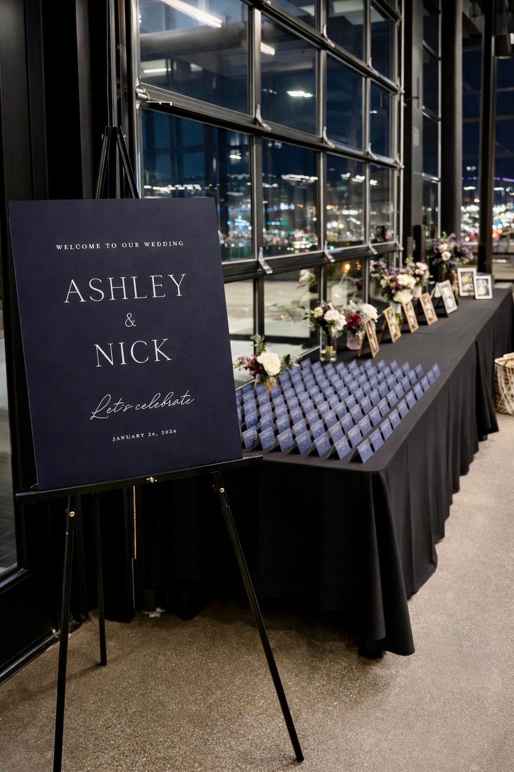 Welcome sign for Ashley & Nick, navy background, on easel. Table with name cards and floral arrangements.
With Love, Wedding management, Milwaukee Wedding Coordinator