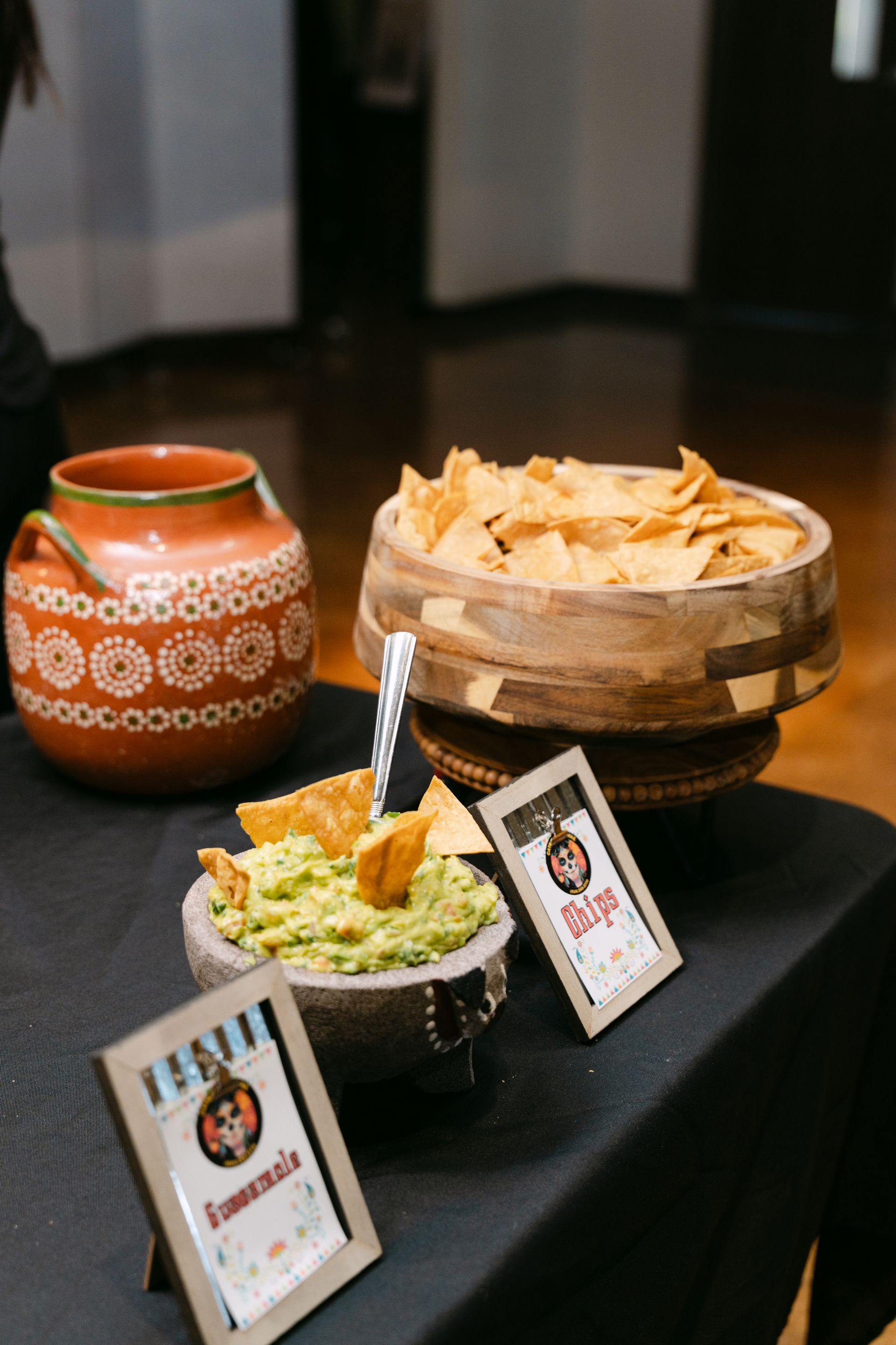 Guacamole, tortilla chips, and salsa displayed at a party.
