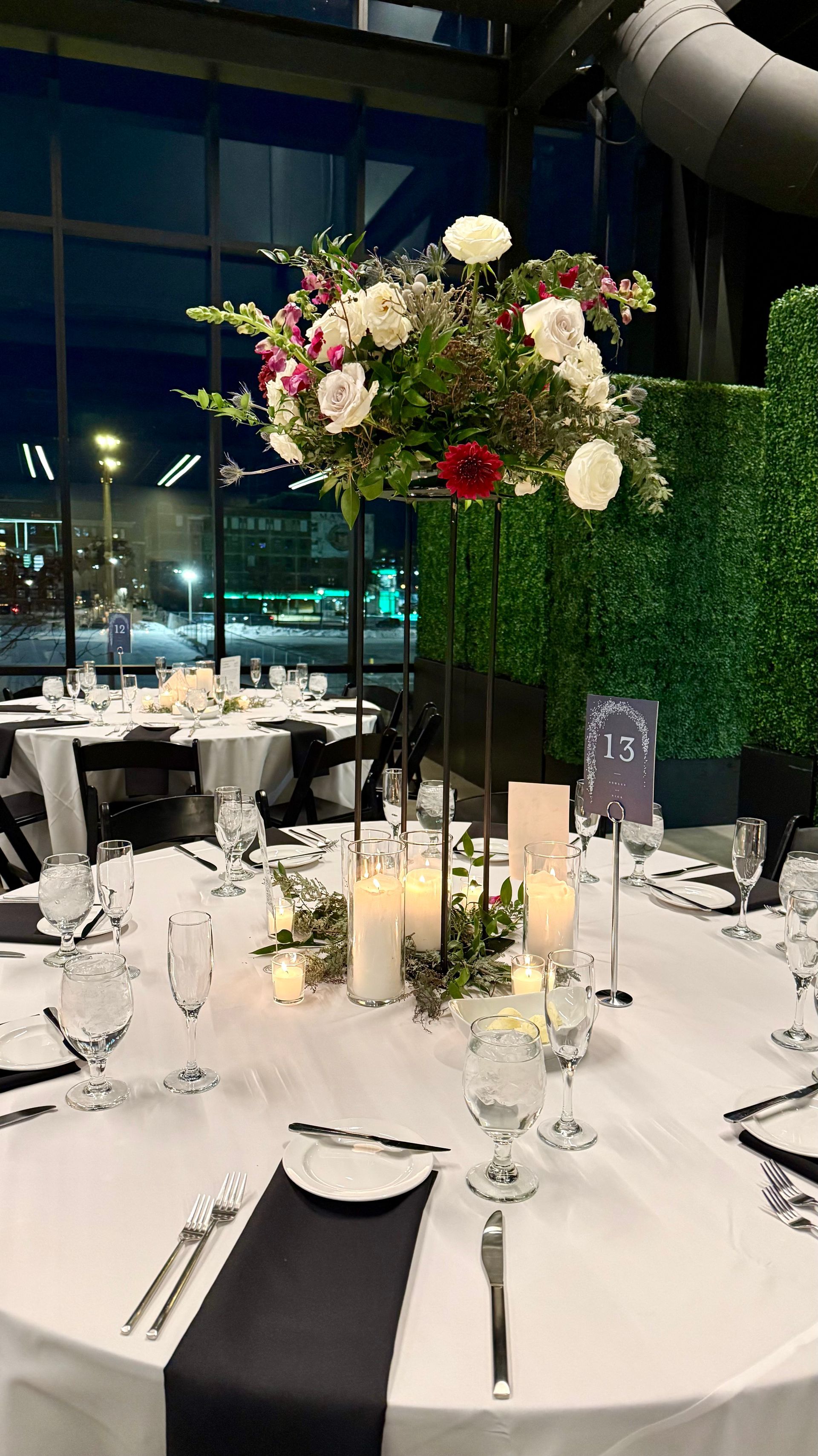 Elegant wedding table setting with floral centerpiece and candles, against an evening city view.
With Love, Wedding management, Milwaukee Wedding Coordinator