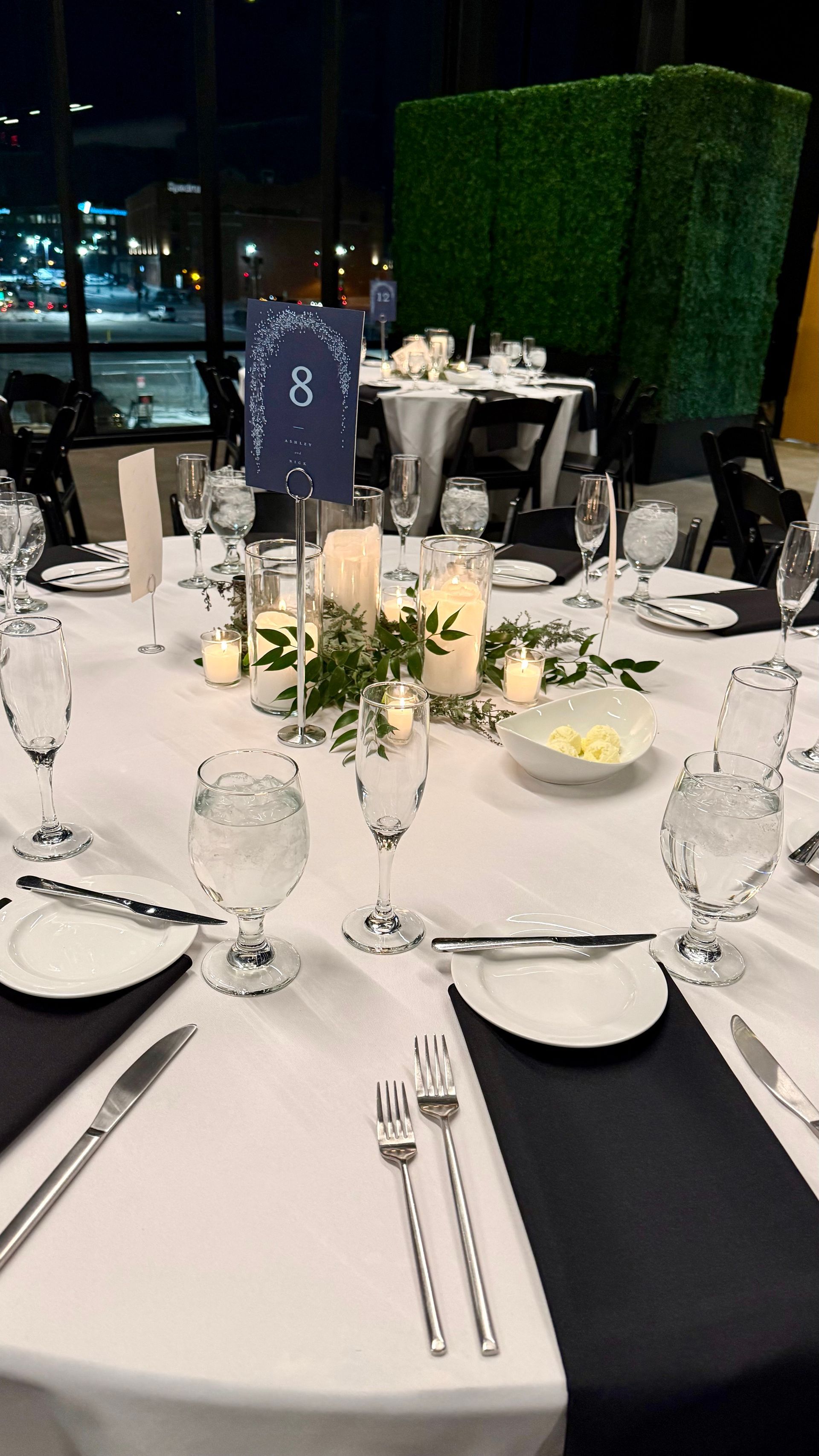 Round table set for a formal event, white tablecloth, navy napkins, candles, greenery, clear glasses, and silverware.
With Love, Wedding management, Milwaukee Wedding Coordinator