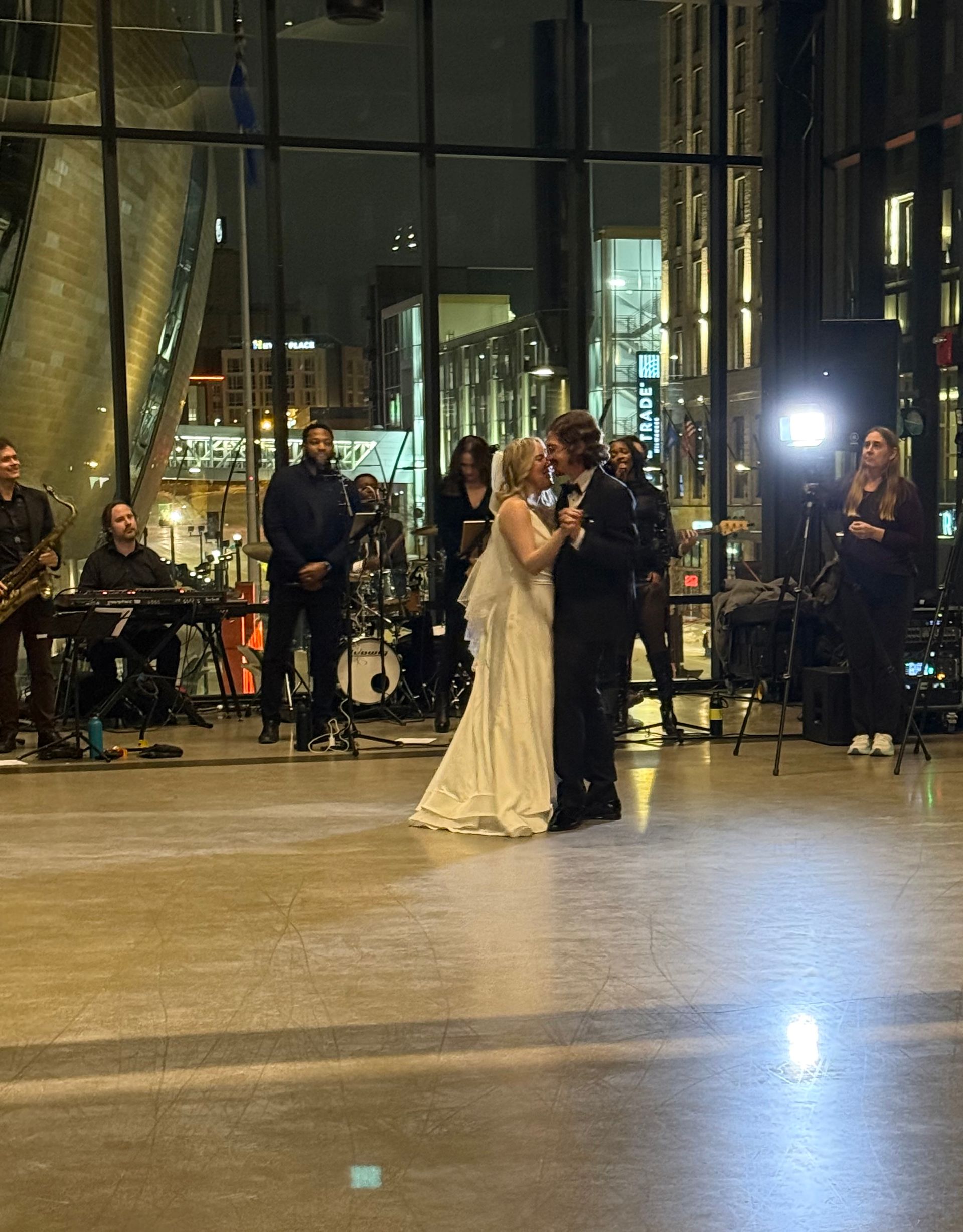 Couple dances in a modern space, band plays nearby. Evening setting with large windows.
With Love, Wedding management, Milwaukee Wedding Coordinator