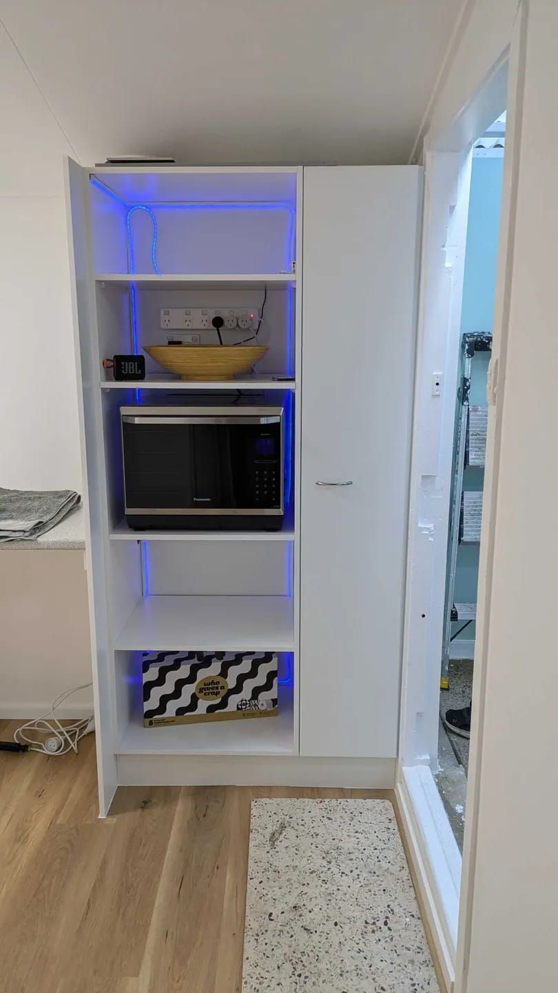 A Microwave Oven Is Sitting On Top Of A White Shelf In A Kitchen — Meredith Kitchens In Moffat Beach, QLD