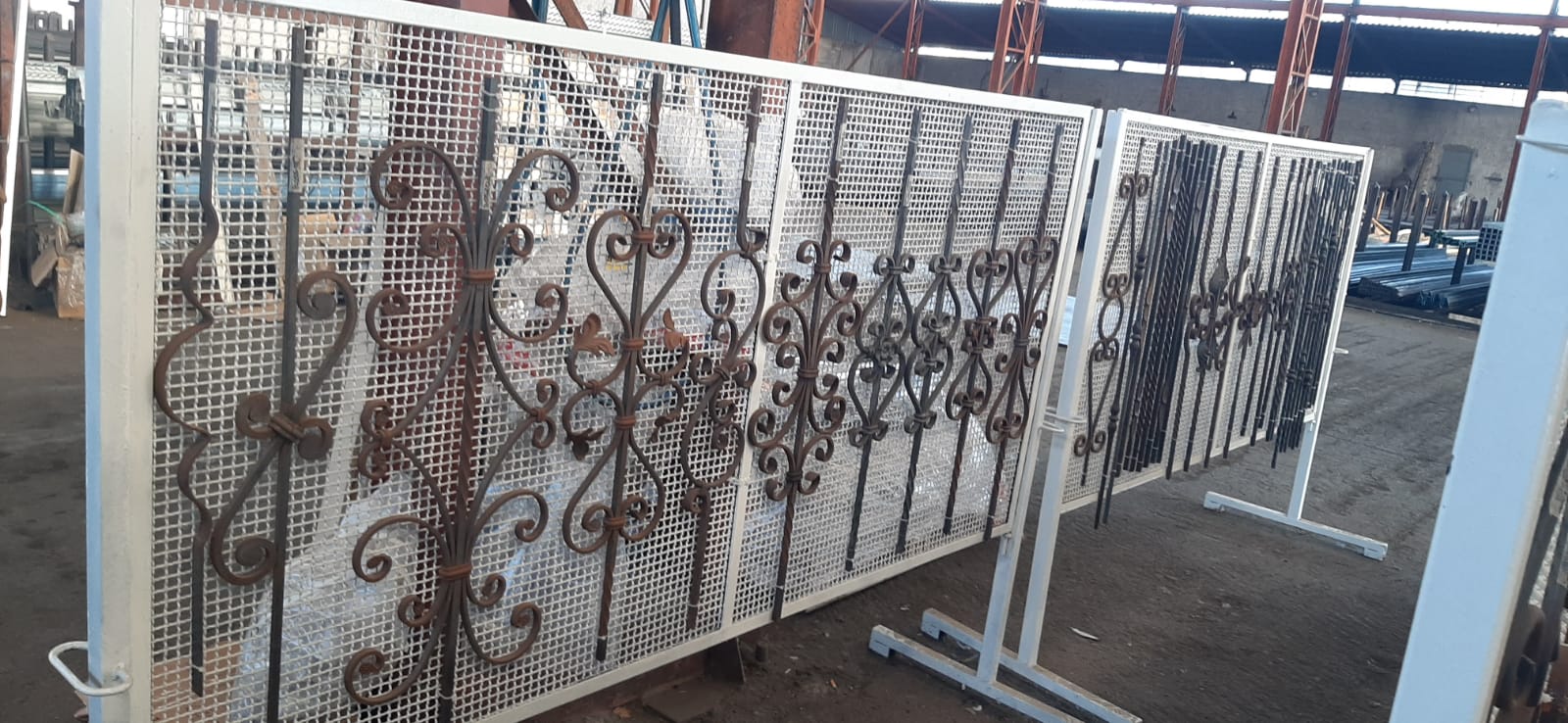 Un mucchio di ferro battuto è appeso a una rastrelliera in un magazzino.