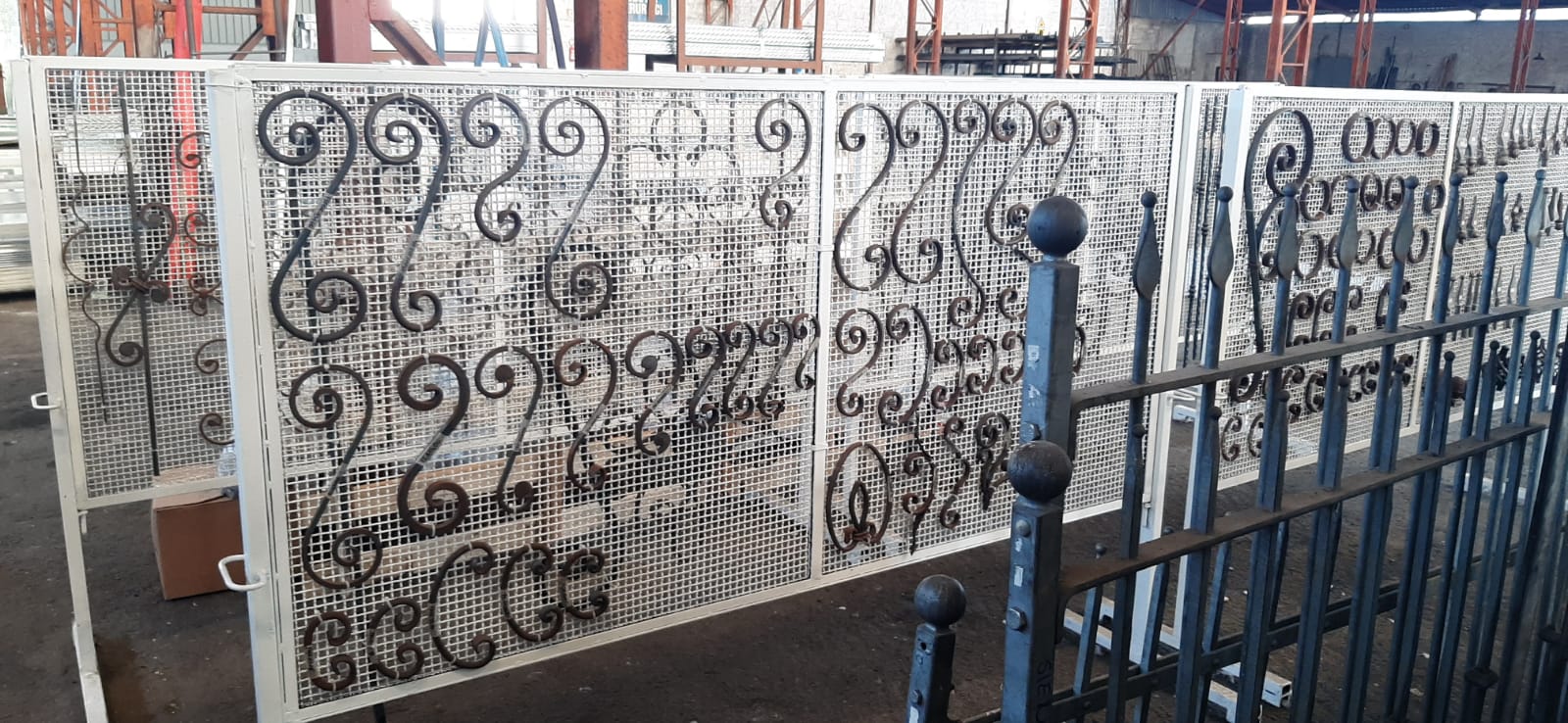 Una recinzione metallica con un motivo è posta accanto a una recinzione metallica.