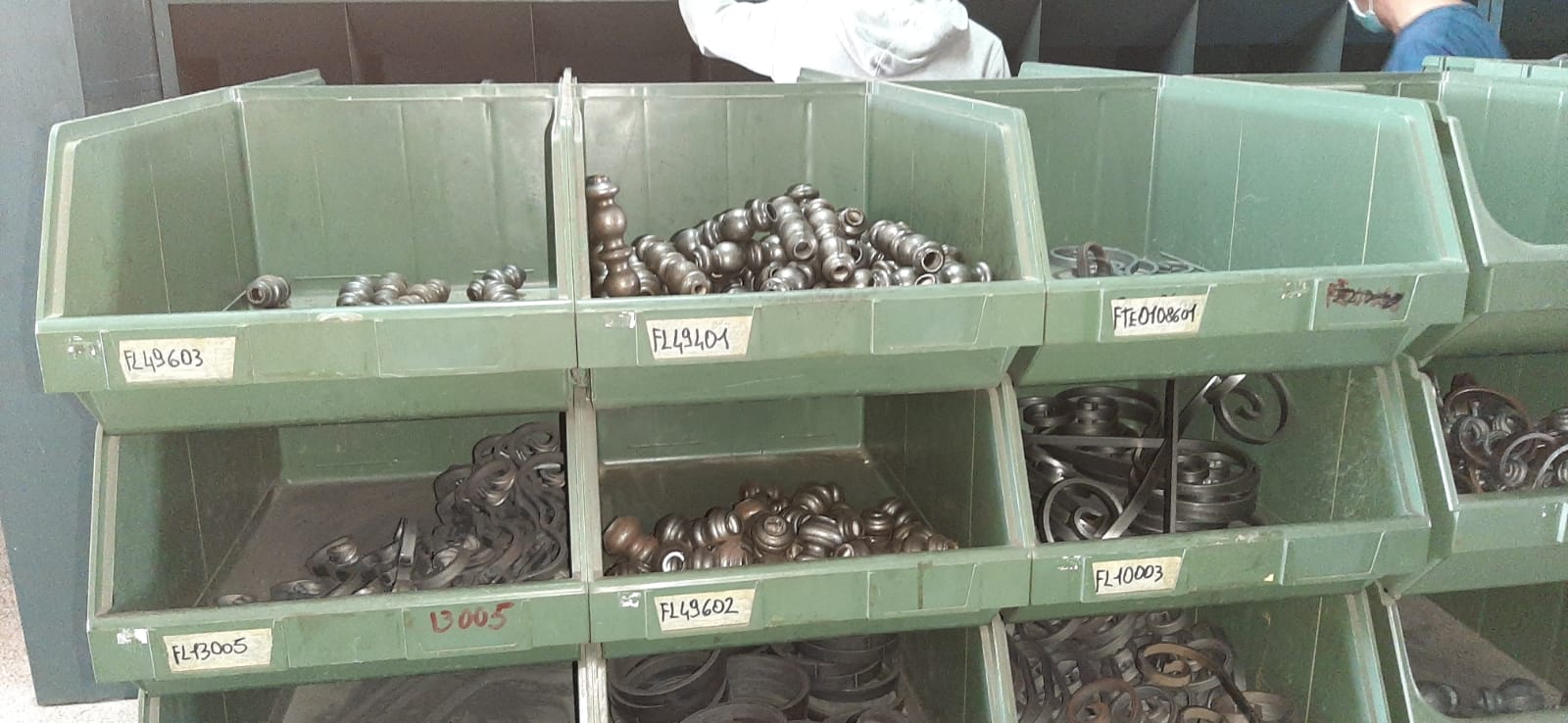 Un mucchio di bidoni verdi pieni di dadi e bulloni.