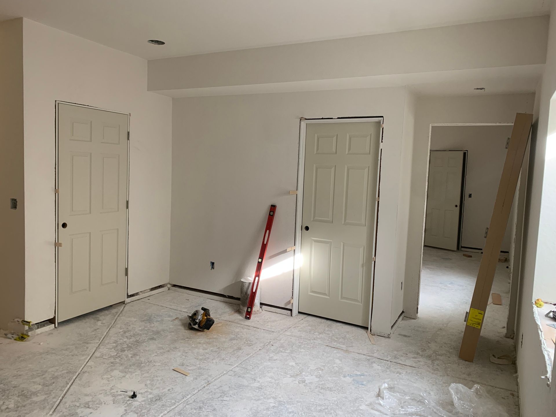 A man is plastering a wall in a room.
